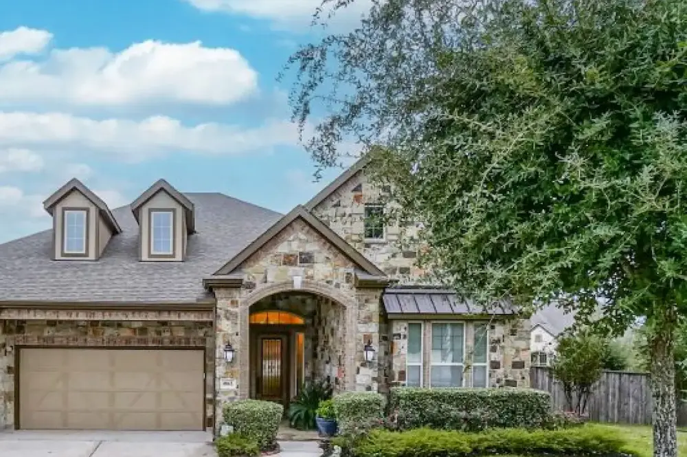 A spacious home featuring a large driveway and an attached garage