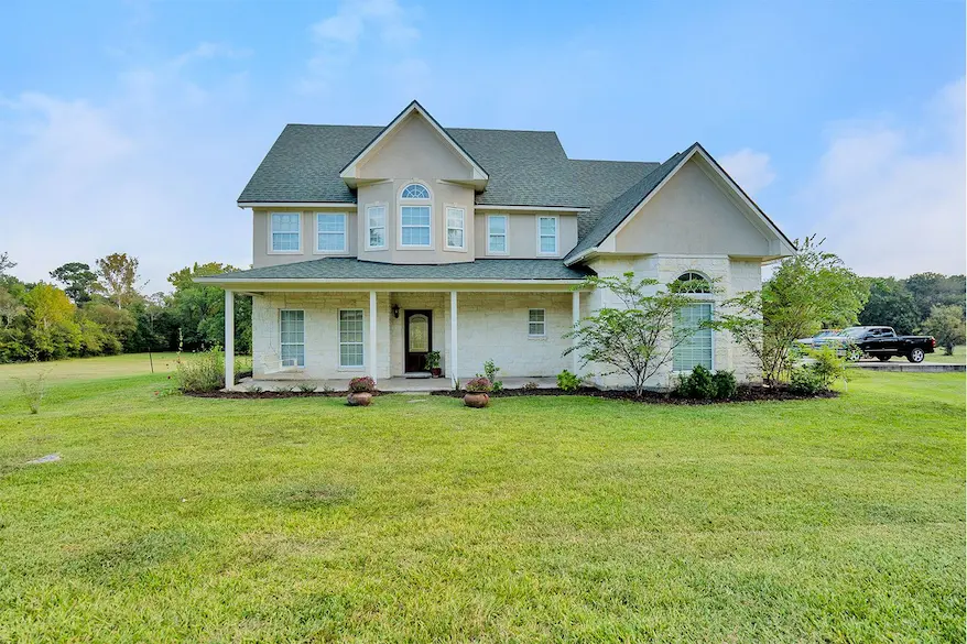 A spacious home with a large yard, ideal for outdoor activities and family gatherings, showcased by a realtor to potential buyers.