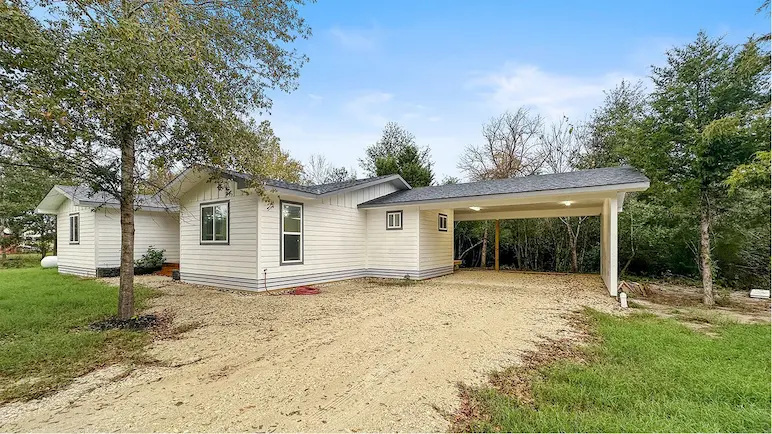 A small house featuring a driveway and garage, ideal for comfortable living and convenient parking.