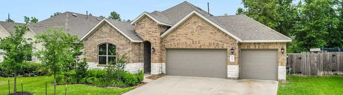 A charming home featuring a garage and a spacious driveway, perfect for parking and easy access.