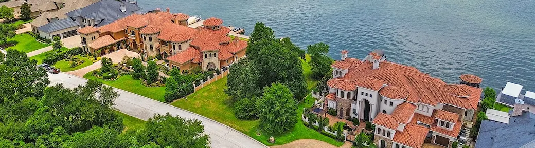 Aerial perspective of a tranquil lake with nearby houses, highlighting a perfect environment for family activities.