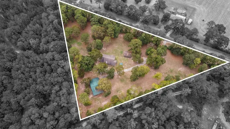 Aerial view of a secluded house surrounded by lush trees