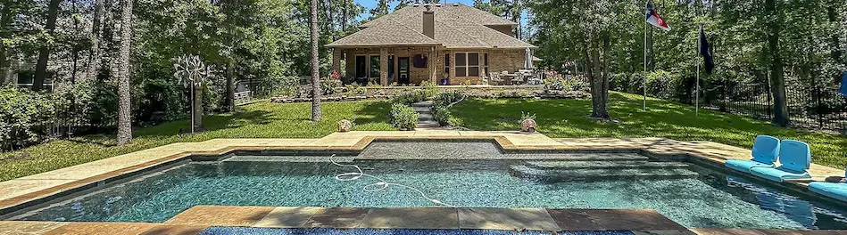 A spacious backyard featuring a sparkling pool and a charming house, perfect for outdoor relaxation and entertaining.