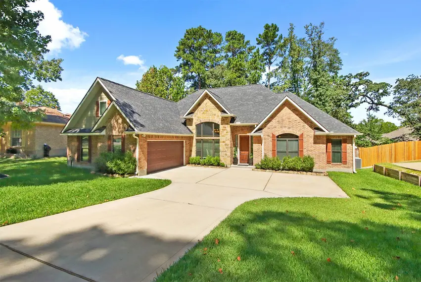 A spacious brick home featuring a driveway and attached garage