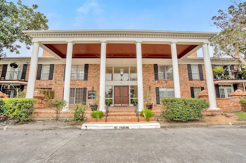 Front view of a brick home featuring a spacious porch