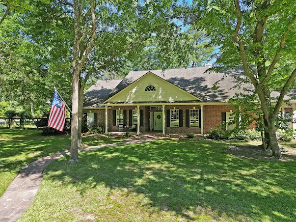 Charming brick home featuring a well-maintained yard with an American flag