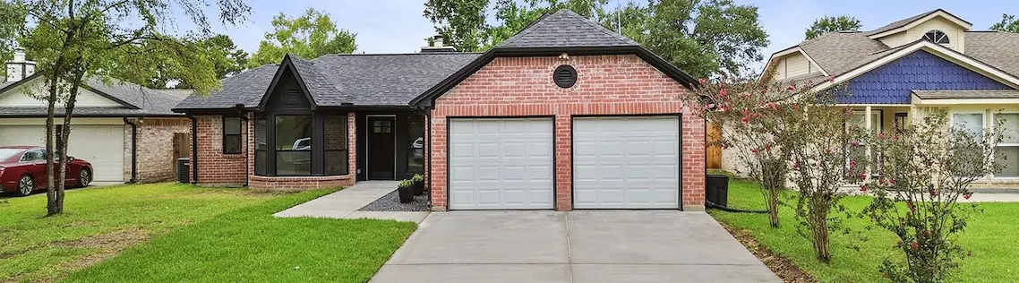 a brick house with a garage and driveway, highlighting its features and curb appeal.