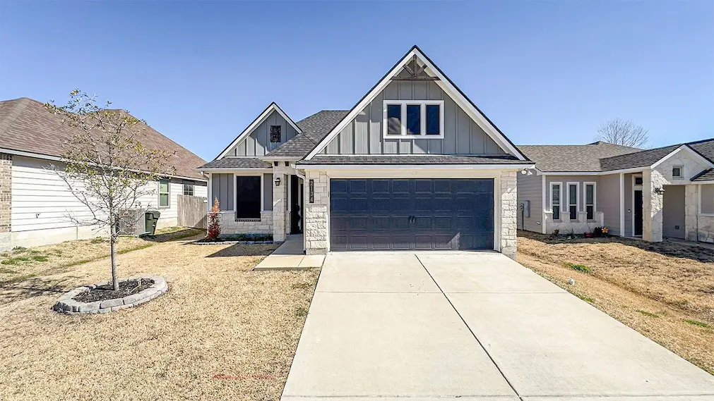 A charming home featuring a spacious garage and a well-maintained driveway