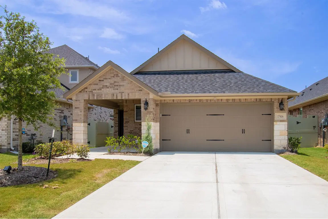 A charming home featuring a spacious driveway and attached garage in the front yard