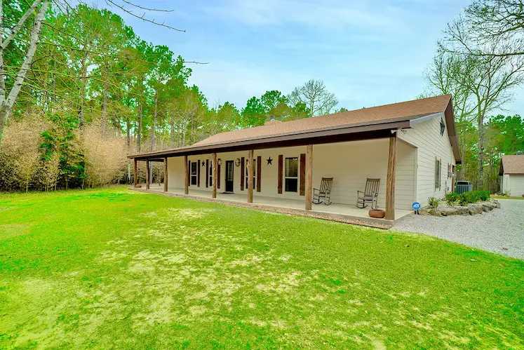 Charming home featuring a welcoming covered porch and a spacious covered patio, perfect for outdoor relaxation and entertaining.