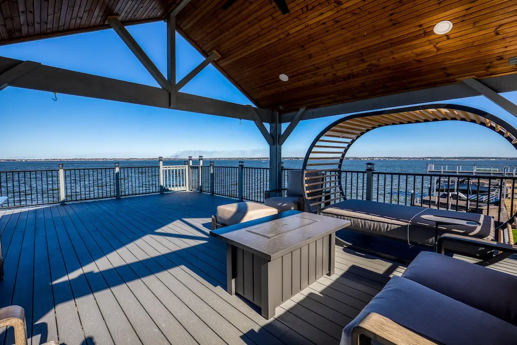 A deck with a gazebo and table offers a scenic view of the water