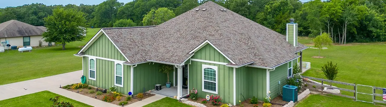 A charming green house featuring a matching green roof, perfect for eco-friendly living and outdoor enjoyment.