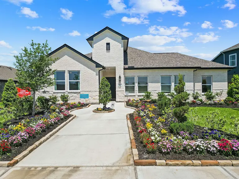 Charming home featuring exquisite landscaping and vibrant flower beds
