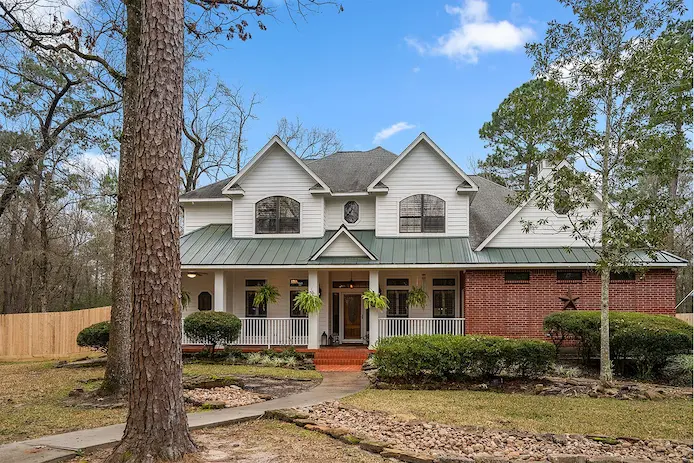 a home with a spacious front yard and a large tree, highlighting the property's outdoor appeal.
