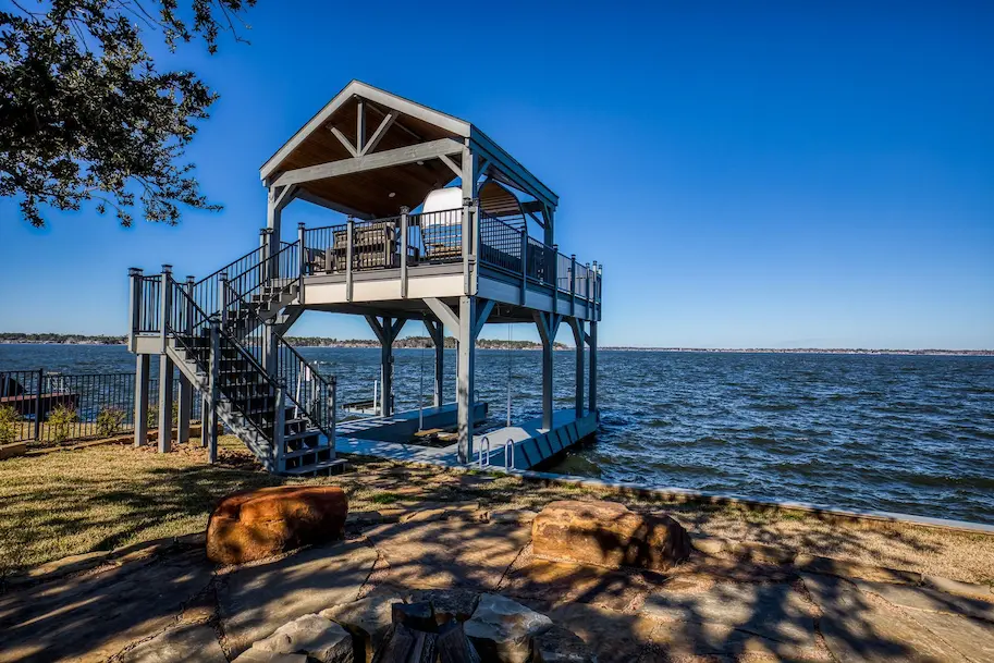 A scenic house on the water with a dock and fire pit