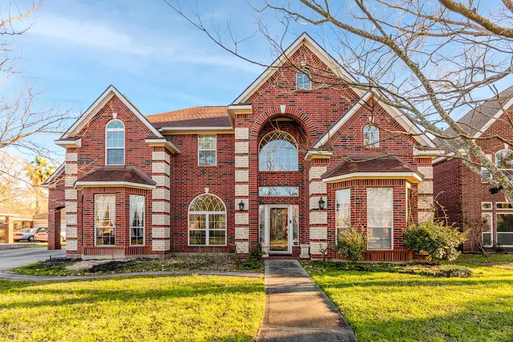 A large brick home with a spacious driveway