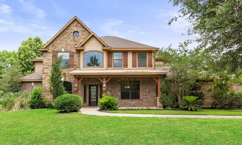 a large home with a spacious front yard and extensive landscaping