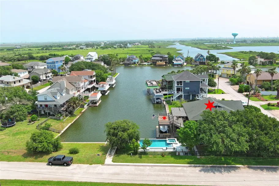 Aerial view of a neighborhood showcasing houses and a nearby body of water