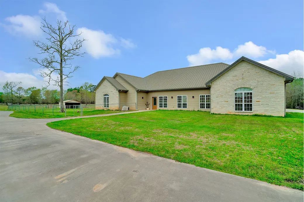 Spacious home featuring a well-maintained driveway and lush green grass, perfect for outdoor activities and family gatherings.
