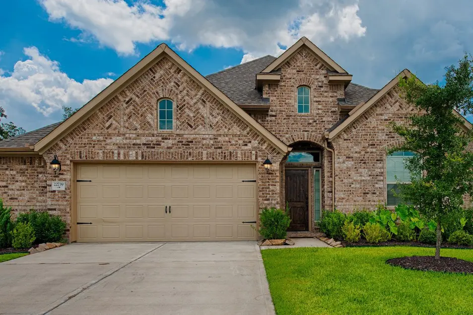 A spacious home featuring a large garage and a wide driveway