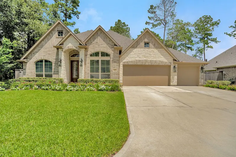 A spacious home featuring a long driveway and a well-maintained grassy lawn, ideal for family gatherings and outdoor activities.