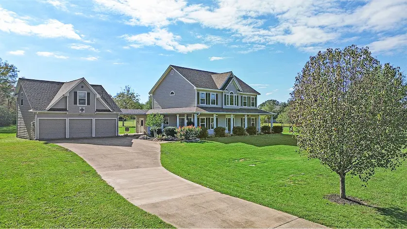 Spacious house with a welcoming driveway and a mature tree,