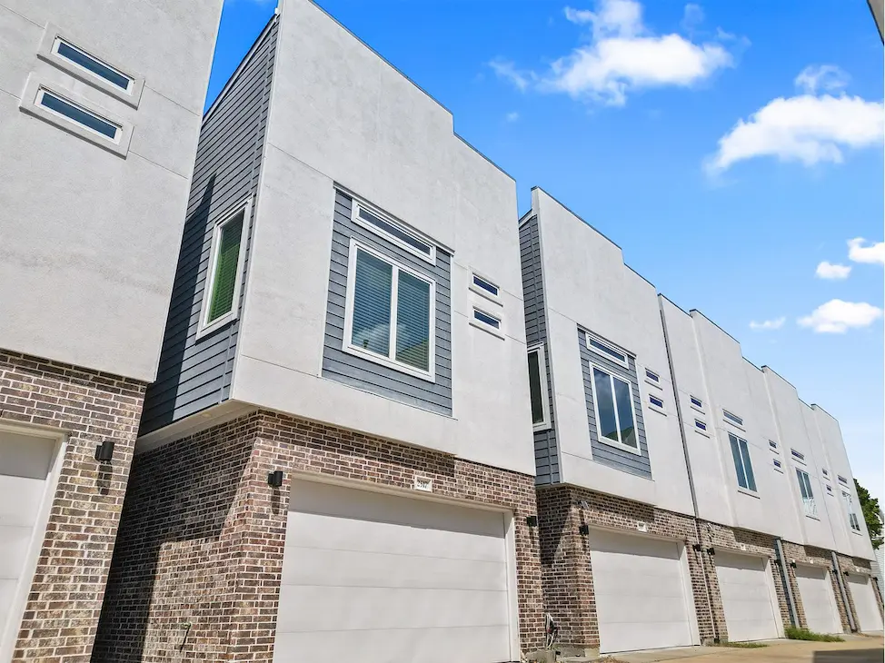 A row of townhouses featuring garages and windows