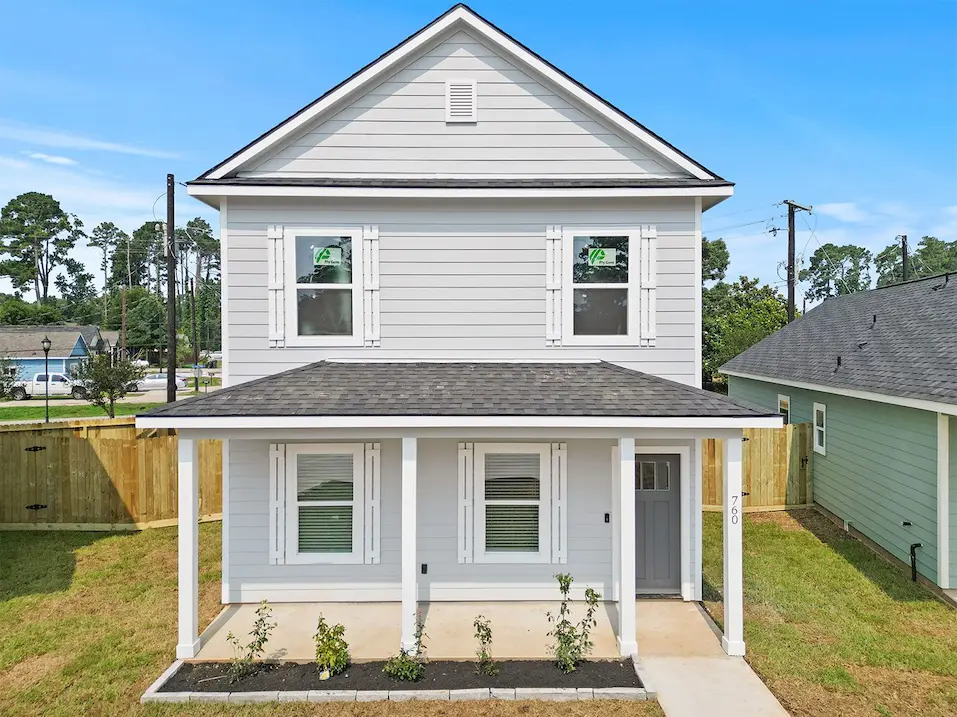 Two-story home featuring a welcoming front porch and a well-maintained front yard