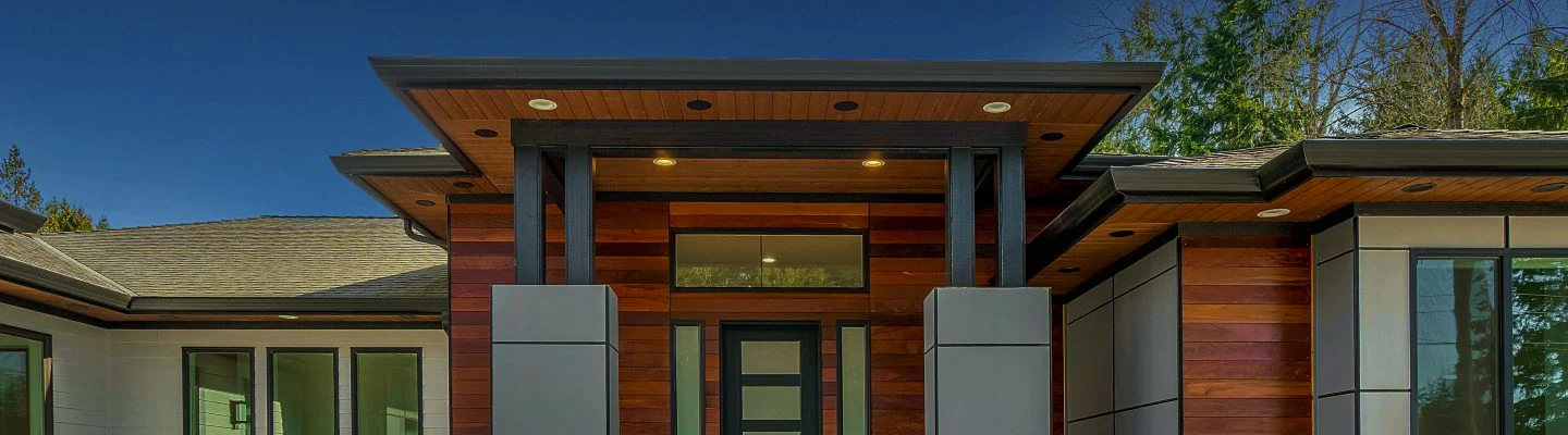 Modern home featuring wooden siding and large glass windows