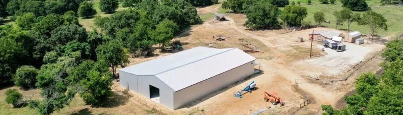 Aerial view showcasing a rustic barn surrounded by a vast, open field