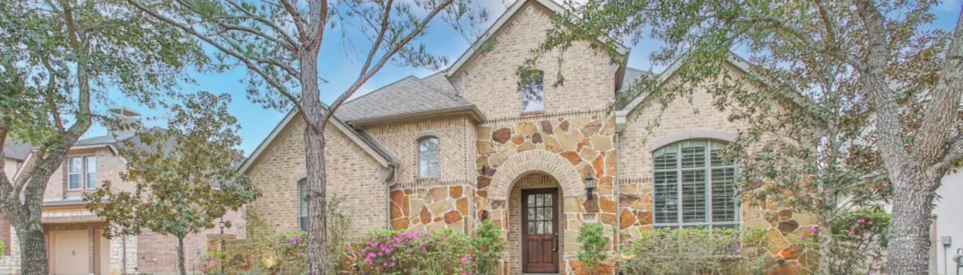 A charming suburban home featuring a well-maintained lawn and inviting front porch, perfect for family living.