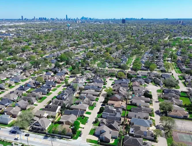 Aerial view of a suburban neighborhood with homes, trees, and streets