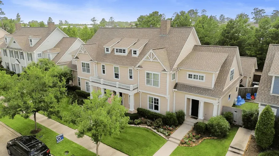 Beautiful suburban home with lush landscaping and a welcoming front porch.