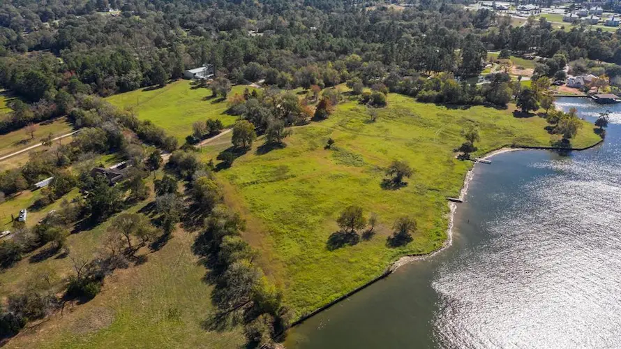 Aerial view showcasing a serene lake surrounded by lush, green forest