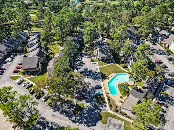 Aerial view of a residential neighborhood featuring homes and a sparkling pool