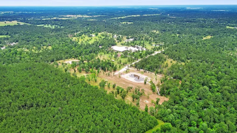 Aerial view of a lush forest surrounding a spacious house