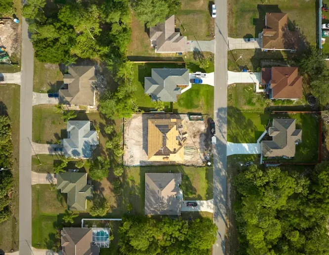 Aerial view of suburban private house wit wooden roof frame under construction