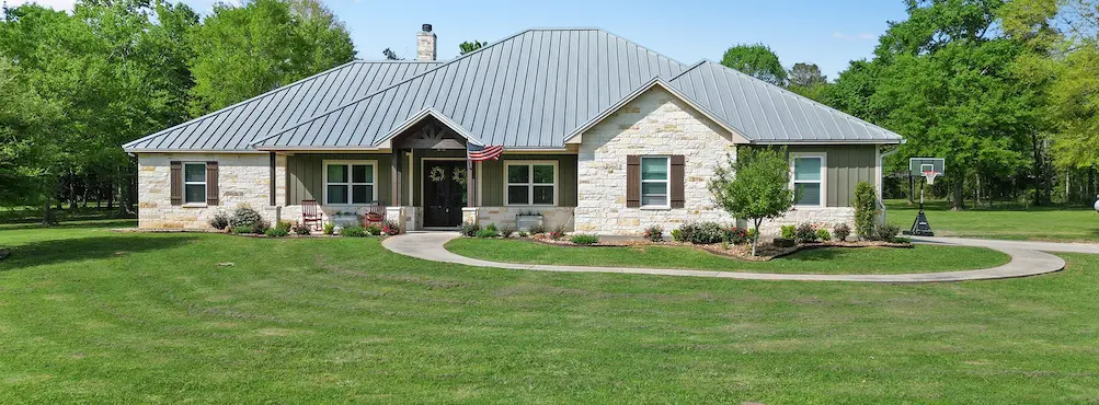 A charming home featuring a spacious yard and a durable metal roof