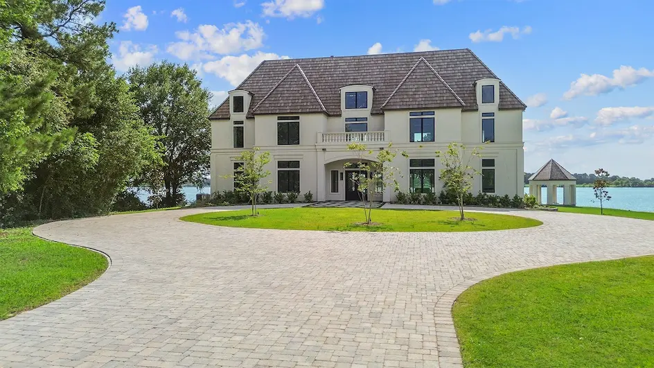 A spacious home featuring a well-maintained lawn and a long driveway