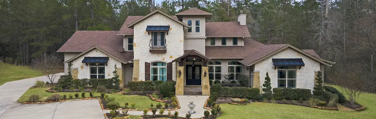 . A spacious home featuring a well-maintained driveway and attractive landscaping