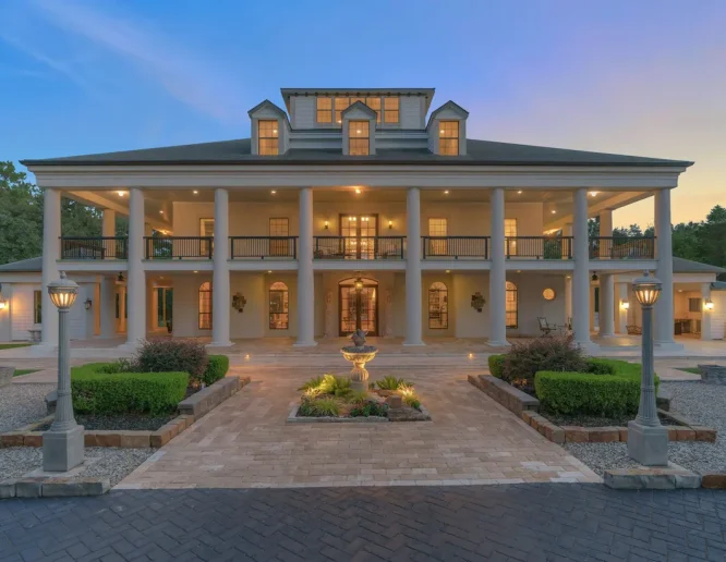 A spacious home featuring a large driveway and an inviting front porch Texas Luxury Homes