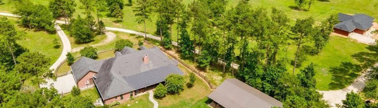 Aerial view of a spacious house nestled among lush trees