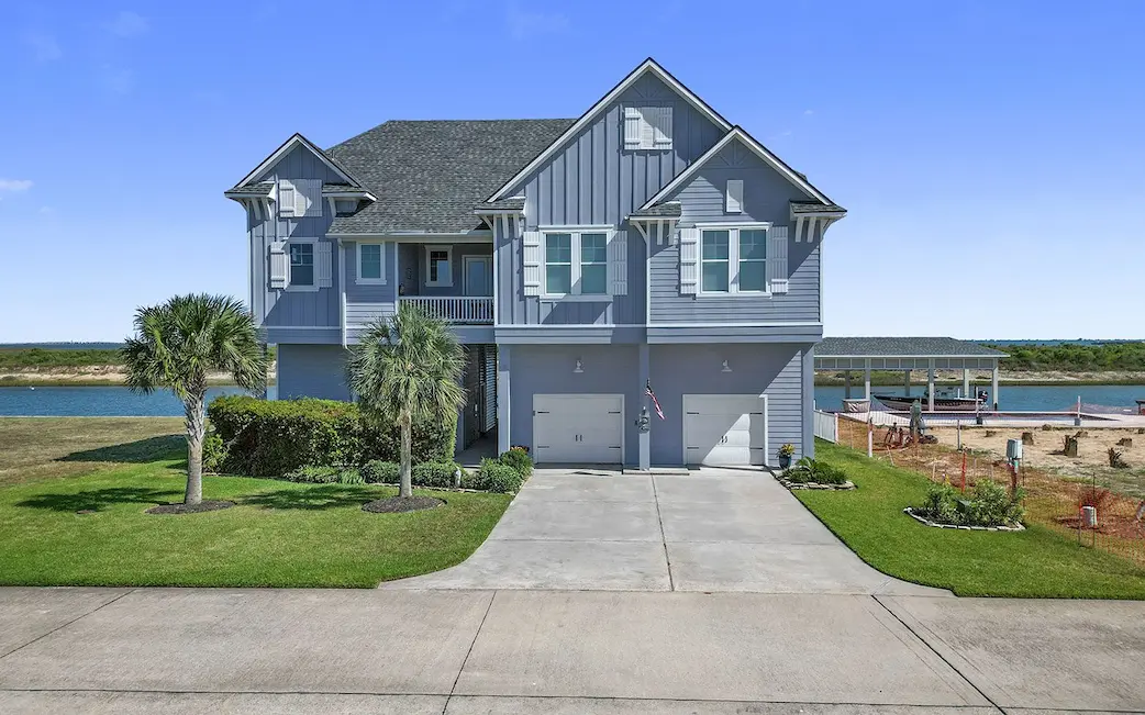 A spacious house featuring a long driveway and a boat dock